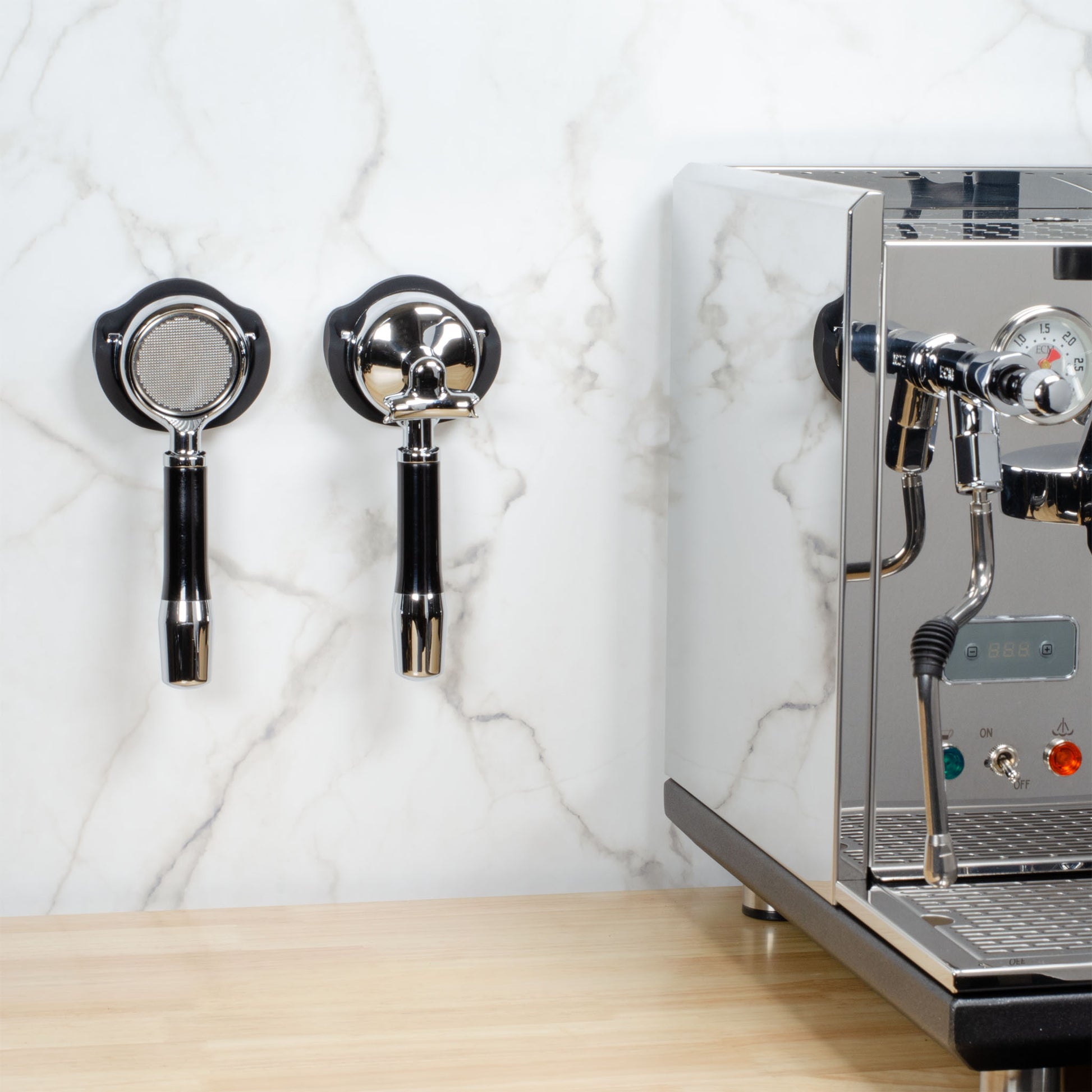 Two ARO Espresso PortaMount holders installed on a white tile backsplash wall beside an espresso machine, each holding a portafilter.