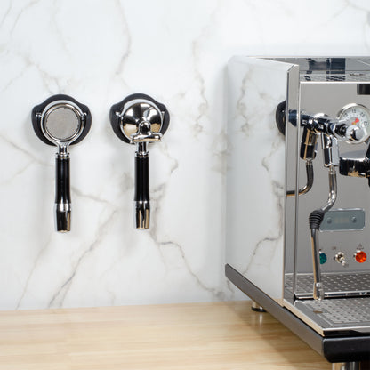 Two ARO Espresso PortaMount holders installed on a white tile backsplash wall beside an espresso machine, each holding a portafilter.